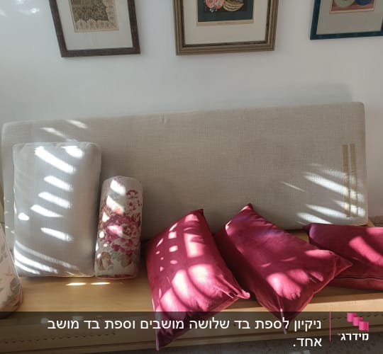 כריות ספה בצבעים שונים מונחות על ספסל עץ